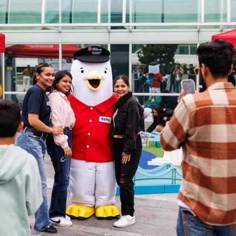 Personnes prenant des photos avec une mascotte de mouette